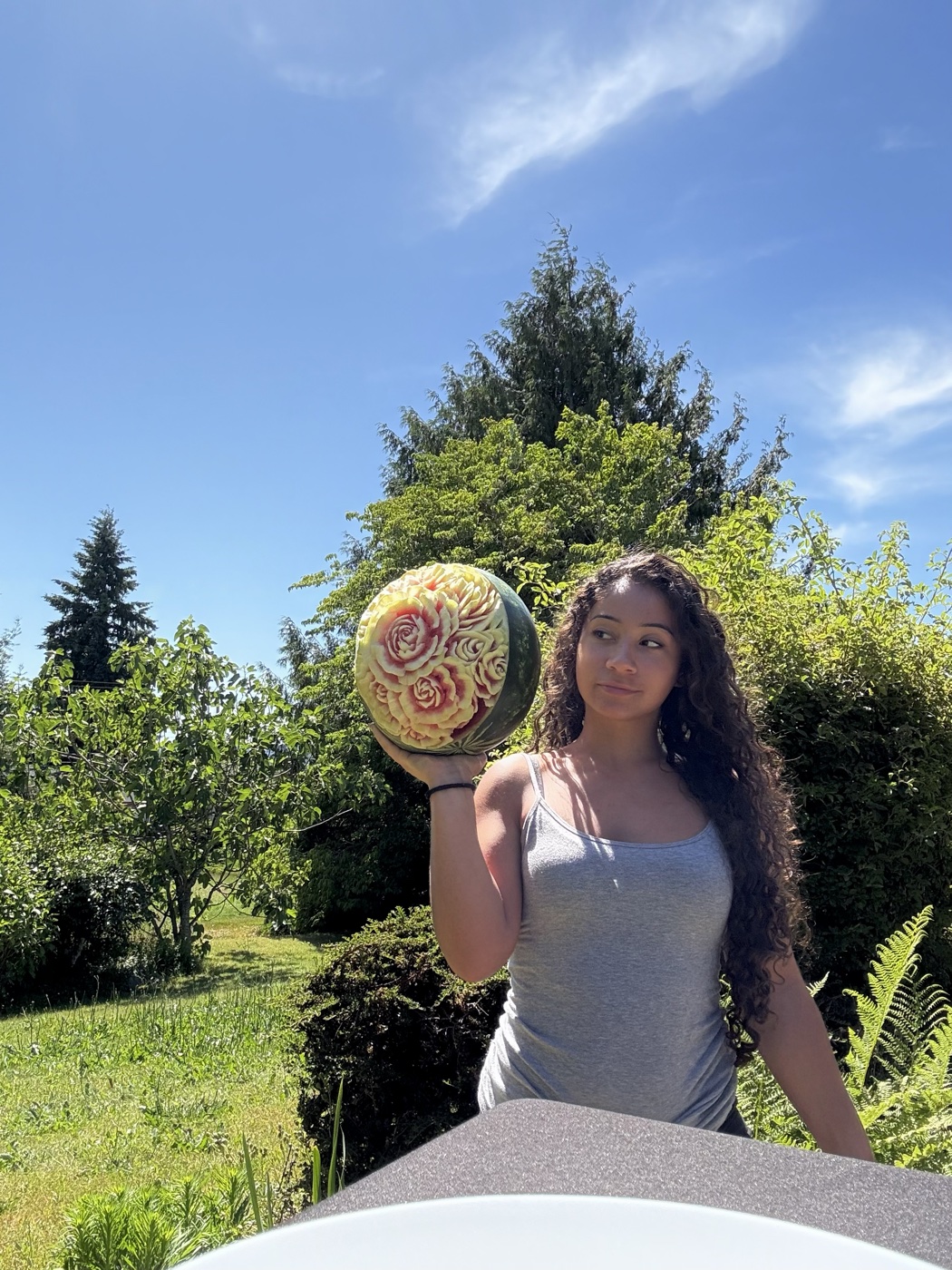 Aliciana, founder of Delicious Designs, holding a watermelon she hand-carved with a rose design